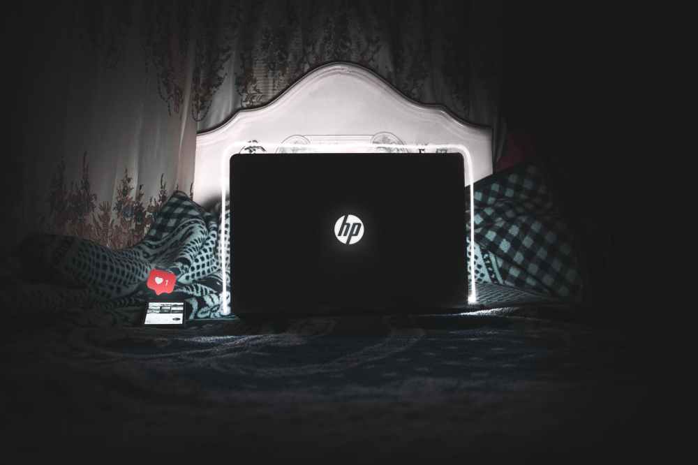 black hp laptop on bed is on